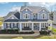 Charming two-story home with a welcoming front porch and well-manicured landscaping at 8638 Raven Top Dr, Mint Hill, NC 28227
