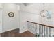 Upstairs hallway featuring hardwood floors, wrought iron banister, and modern light fixtures at 8638 Raven Top Dr, Mint Hill, NC 28227