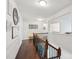 Upstairs hallway with wooden floors, wrought iron banister, decorative wall hangings, and seating at 8638 Raven Top Dr, Mint Hill, NC 28227