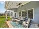 Covered back patio featuring a ceiling fan, comfortable seating, and a view of the landscaped yard at 8638 Raven Top Dr, Mint Hill, NC 28227