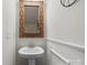 Charming half-bathroom featuring a bamboo-framed mirror and elegant pedestal sink at 9042 Northfield Crossing Dr, Charlotte, NC 28269