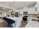 Bright, open kitchen features white cabinetry, stainless steel appliances, and a large island with pendant lighting at 9042 Northfield Crossing Dr, Charlotte, NC 28269