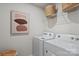 Bright laundry room with modern washer and dryer, overhead storage, and stylish decor at 9042 Northfield Crossing Dr, Charlotte, NC 28269