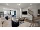 Open-concept living room with a comfortable sofa, adjacent to the kitchen and featuring a staircase at 9042 Northfield Crossing Dr, Charlotte, NC 28269