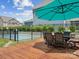 Backyard featuring a deck with outdoor dining set, a pool with black metal fence, and green landscaping at 924 Stebbins Dr, Fort Mill, SC 29715