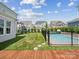 Expansive backyard with well-maintained lawn, fenced pool, and playground, creating a perfect space for Gathering fun at 924 Stebbins Dr, Fort Mill, SC 29715