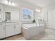 Bright bathroom featuring a soaking tub, double vanity with white cabinets, and tile flooring at 924 Stebbins Dr, Fort Mill, SC 29715