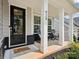 Inviting front porch featuring rocking chairs, white columns, and a decorative front door at 924 Stebbins Dr, Fort Mill, SC 29715