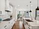 Well-lit kitchen with stainless steel appliances, a farmhouse sink, and an open view into the dining area at 924 Stebbins Dr, Fort Mill, SC 29715