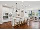 Modern kitchen with white cabinetry, large island with seating, stainless steel appliances, and hardwood floors at 924 Stebbins Dr, Fort Mill, SC 29715