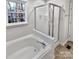 Bathroom featuring a tub, shower with sliding door, and a window for ventilation at 10301 Shelter Rock Ct, Charlotte, NC 28214