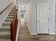 Inviting hallway featuring hardwood floors and a staircase with wood railing at 10301 Shelter Rock Ct, Charlotte, NC 28214