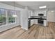 Bright kitchen boasts stainless steel appliances, white cabinets, and views from the dining area's windows at 10301 Shelter Rock Ct, Charlotte, NC 28214