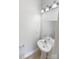 Well-lit powder room with a modern pedestal sink, mirror, and light fixture against neutral walls at 104 Tarrington Dr, Statesville, NC 28625
