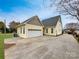 Charming, yellow home featuring an attached two-car garage and long, paved driveway under a clear blue sky at 104 Tarrington Dr, Statesville, NC 28625