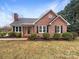 Charming brick home with black shutters and well-maintained landscaping in a tranquil neighborhood at 106 Cape Breton Trl, Gastonia, NC 28056