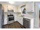 Classic kitchen with stainless steel appliances, white cabinets, and durable wood flooring at 106 Cape Breton Trl, Gastonia, NC 28056