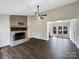 Bright living room featuring a brick fireplace and seamlessly transitioning to a sunlit kitchen area at 106 Cape Breton Trl, Gastonia, NC 28056