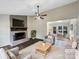 Cozy living room with fireplace and stylish ceiling fan, seamlessly flowing into the dining area at 106 Cape Breton Trl, Gastonia, NC 28056