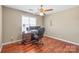 Bedroom with hardwood floors featuring a ceiling fan and a desk area at 10615 Persimmon Creek Dr, Mint Hill, NC 28227