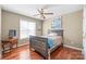 Bedroom featuring hardwood floors, a ceiling fan, a bed and a side table at 10615 Persimmon Creek Dr, Mint Hill, NC 28227