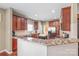 Beautiful kitchen features granite countertops, wooden cabinets, stainless steel appliances, and breakfast bar at 10615 Persimmon Creek Dr, Mint Hill, NC 28227
