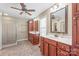 Well-lit main bathroom featuring dual vanities, a walk-in shower, and a large mirror at 10615 Persimmon Creek Dr, Mint Hill, NC 28227