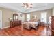 Traditional-style main bedroom with hardwood floors, vintage furniture, and ample natural light from the windows at 10615 Persimmon Creek Dr, Mint Hill, NC 28227
