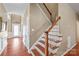 Elegant staircase with wooden railings and white spindles, complemented by hardwood floors in the entryway at 10615 Persimmon Creek Dr, Mint Hill, NC 28227