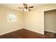 Bright bedroom featuring hardwood floors, a ceiling fan, and a window offering natural light at 107 Stanford Dr, Stanley, NC 28164