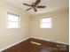 Bedroom with hardwood floors and neutral walls, illuminated by natural light from two windows at 107 Stanford Dr, Stanley, NC 28164
