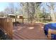 Spacious wooden deck with railings overlooking the wooded yard with outbuildings, ideal for outdoor living at 107 Stanford Dr, Stanley, NC 28164