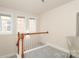 Bright hallway with natural light from the windows, wood railing and neutral colors at 10911 Round Rock Rd, Charlotte, NC 28277