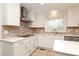 A kitchen featuring white cabinetry, stainless steel appliances, and earth-toned backsplash at 10914 Ridge Acres Rd, Charlotte, NC 28214