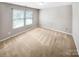 Bright bedroom with neutral walls, new carpeting, and a large window at 114 Sheridan Ct, Mooresville, NC 28115