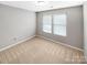 Cozy bedroom with neutral walls, plush carpeting, and ample natural light from a large window at 114 Sheridan Ct, Mooresville, NC 28115