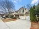Charming two-story home with a two-car garage and manicured landscaping on a sunny day at 114 Sheridan Ct, Mooresville, NC 28115