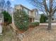 Tan two-story home with a red front door, landscaping, and a two-car garage on a sunny day at 114 Sheridan Ct, Mooresville, NC 28115