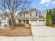 Charming two-story home with a two-car garage, red door, and manicured landscaping at 114 Sheridan Ct, Mooresville, NC 28115