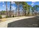 View of the spacious backyard showcasing an expansive lawn and mature trees for a serene outdoor experience at 13101 Cozy Ct, Charlotte, NC 28215