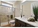 Bathroom with glass enclosed shower, dark wood cabinets, white countertop, and large mirror at 13101 Cozy Ct, Charlotte, NC 28215