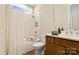 Bathroom showcasing a tub with shower, white tile surround, and wood vanity with countertop sink at 13101 Cozy Ct, Charlotte, NC 28215