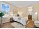 Sunlit bedroom featuring a bed with white linens, window view, and access to an ensuite bathroom at 13101 Cozy Ct, Charlotte, NC 28215