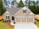Charming single-Gathering home featuring a three-car garage, stone accents, and manicured landscaping at 13101 Cozy Ct, Charlotte, NC 28215