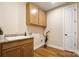 Well-lit laundry room with wood floors, granite countertop sink, and ample cabinet space at 13101 Cozy Ct, Charlotte, NC 28215