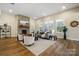 Bright living room featuring a stone fireplace, wood floors, and modern furniture at 13101 Cozy Ct, Charlotte, NC 28215