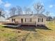 Charming single-story home featuring a welcoming front porch and a well-maintained yard on a sunny day at 1311 Shady Oak Trl, Gastonia, NC 28052