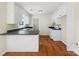 Efficient kitchen featuring white cabinets, dark countertops, and hardwood floors at 1311 Shady Oak Trl, Gastonia, NC 28052