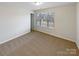 Bright bedroom featuring a window view, neutral walls, and cozy carpeting, offering a serene space at 133 Sequoia St, Mooresville, NC 28117