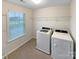 A laundry room with a washer, a dryer, and metal shelving at 133 Sequoia St, Mooresville, NC 28117